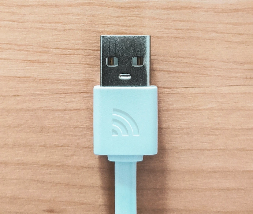 USB Kabel auf Holz mit Uniport Logo. Foto von Sigmund @ Unsplash.