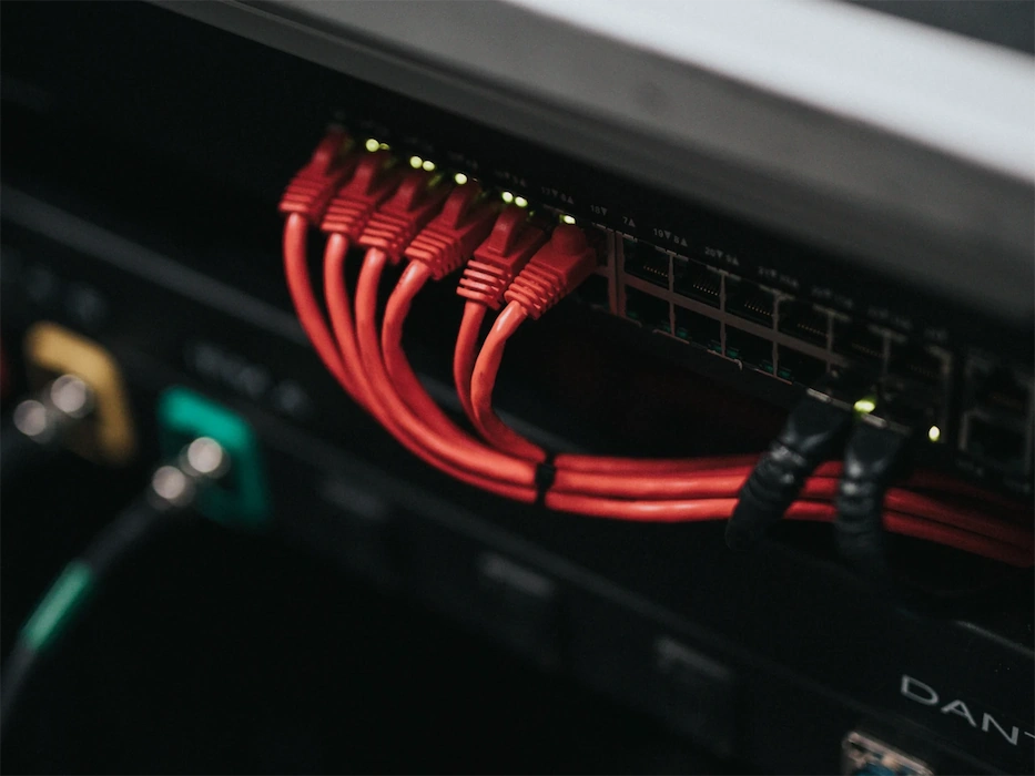 Kabel an einem Netzwerkschrank. Foto von Nathan Dumlao @ Unsplash.
